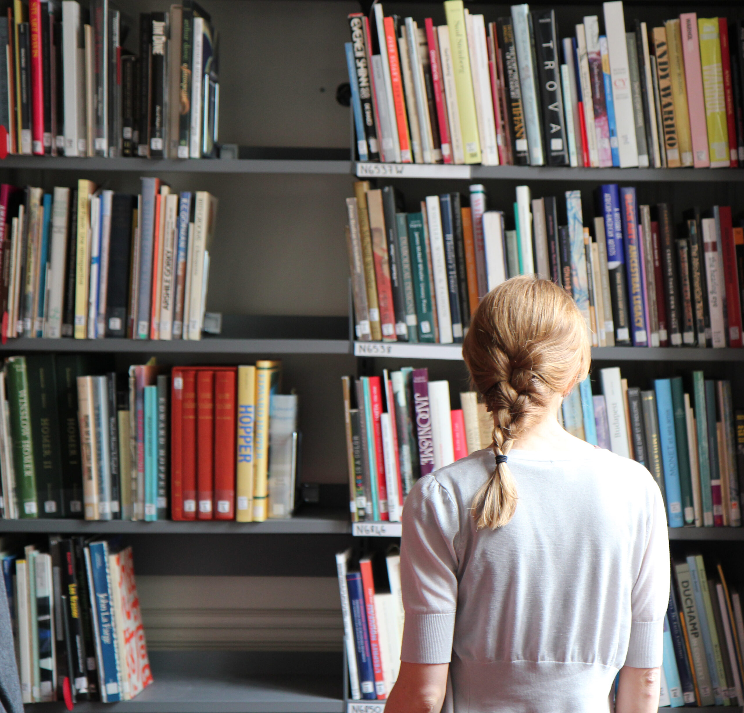 A person standing in front of shelves of books.