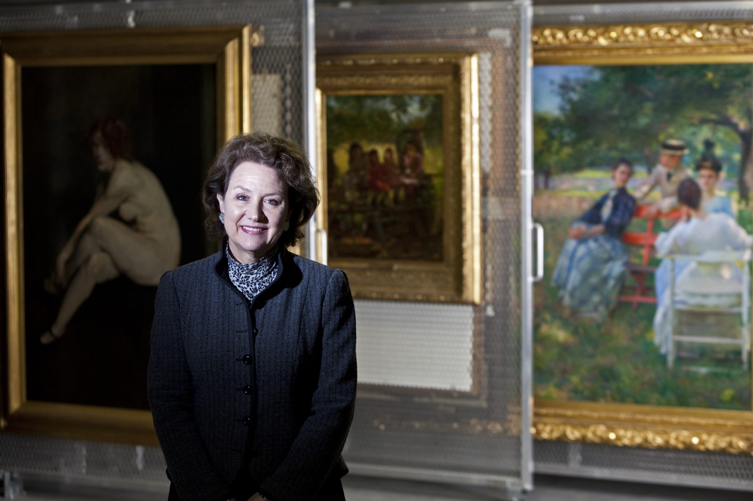 Elizabeth Glassman standing in front of paintings in the Terra Foundation collection vault.