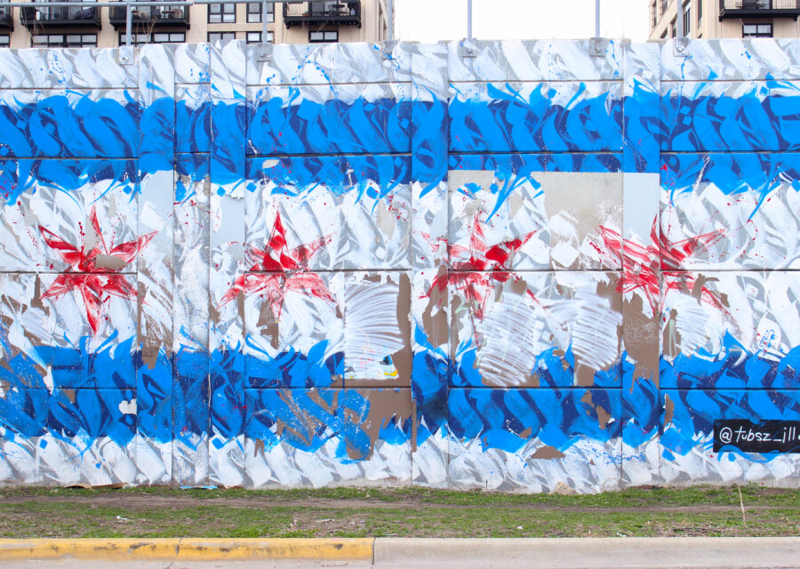 Photo of graffiti on a wall created with types forms. The graffiti resembles the Chicago flag. There are white and blue horizontal stripes with four red stars in the center.