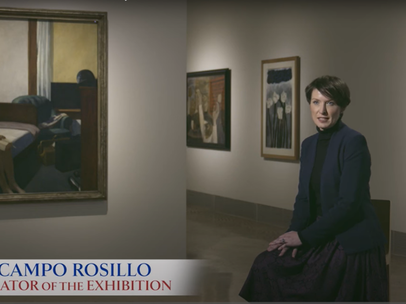 Woman seated in a gallery.