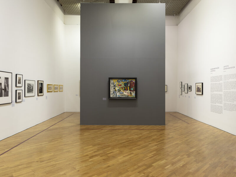 Installation photograph of framed paintings on three walls.