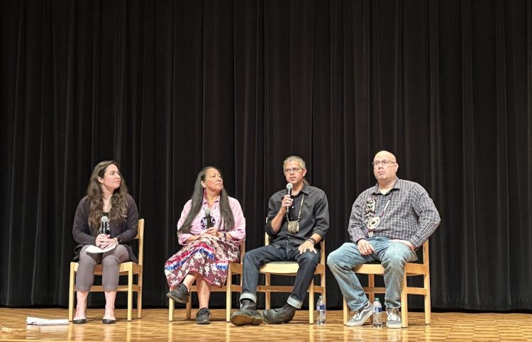 An image of a group of people sitting on stage.
