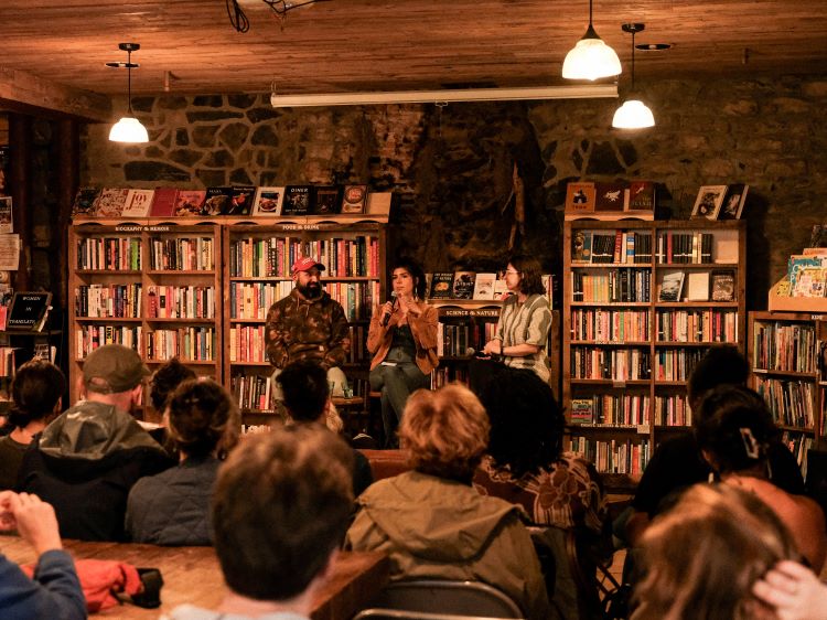 An image of a people seated listening to someone talk in front of them.