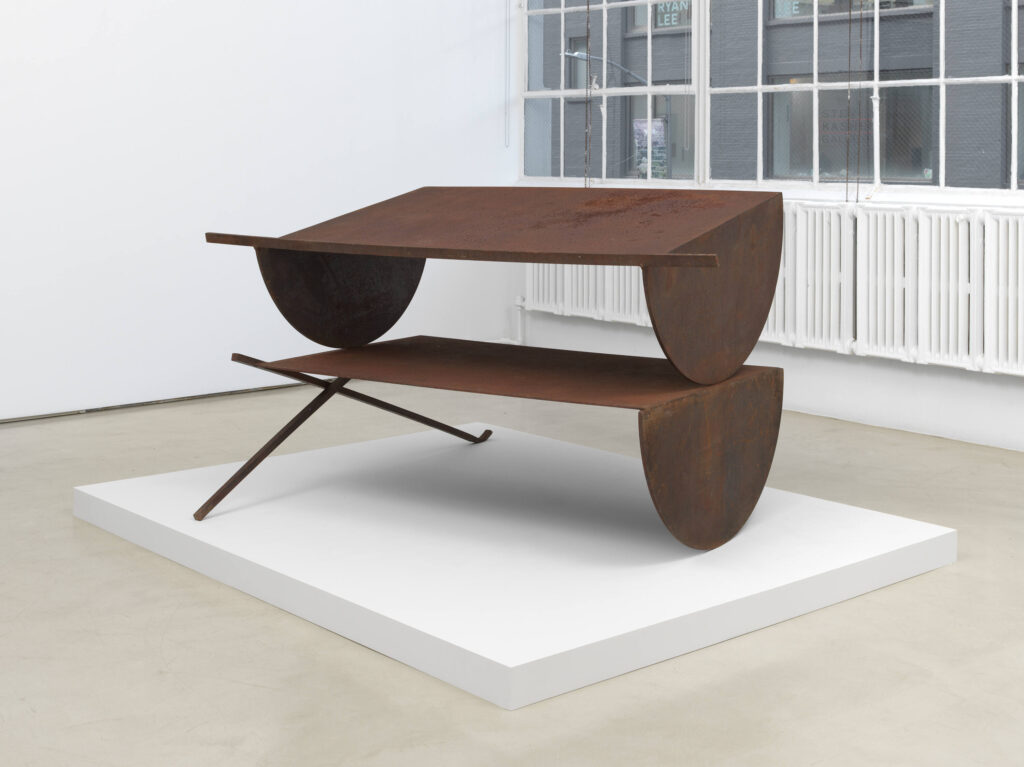 Steel sculpture on a white rectangular platform.