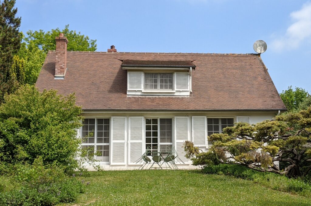 Exterior of Hervieux House, with white shutter and slopped shingled roof.
