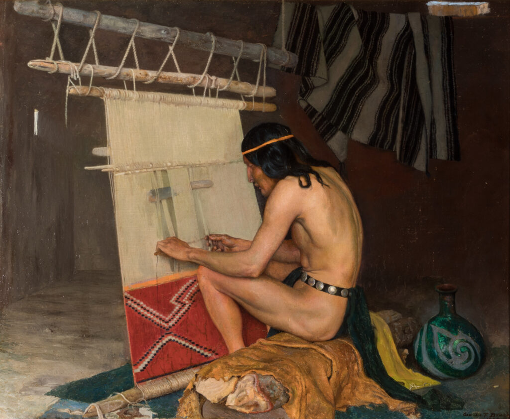 A Native American man sits at a loom and weaves a textile.