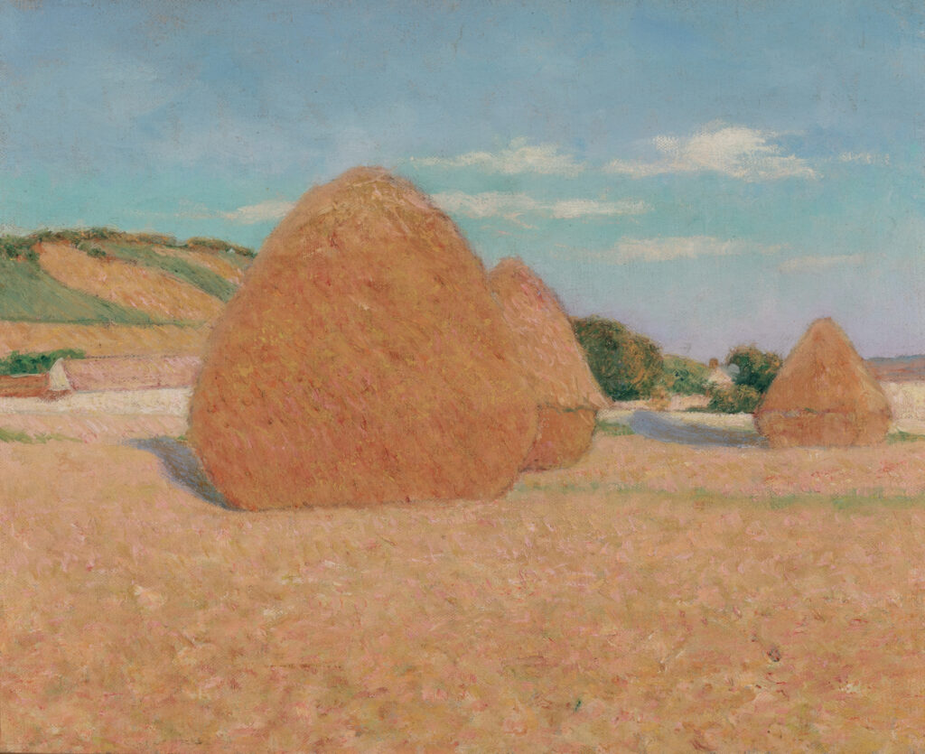 Three haystacks in sunlight.