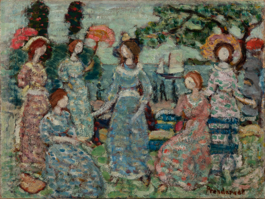 A group of women sitting in a park by the sea.
