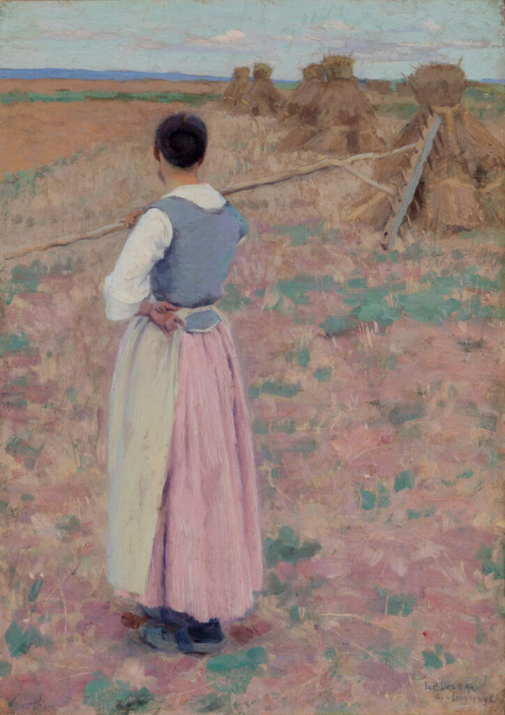 A woman stands in a field and holds a pitchfork over her shoulder. Behind her are triangular stacks of wheat.
