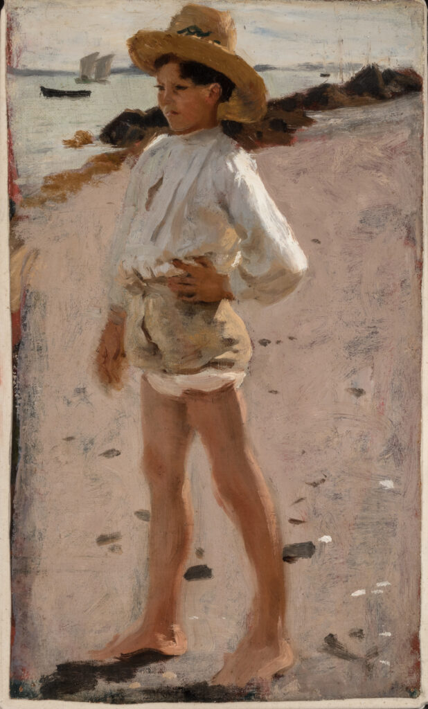 A boy standing on a beach.