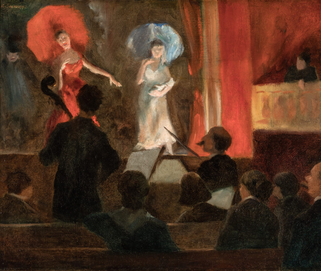 Two people stand on a stage in a theater.