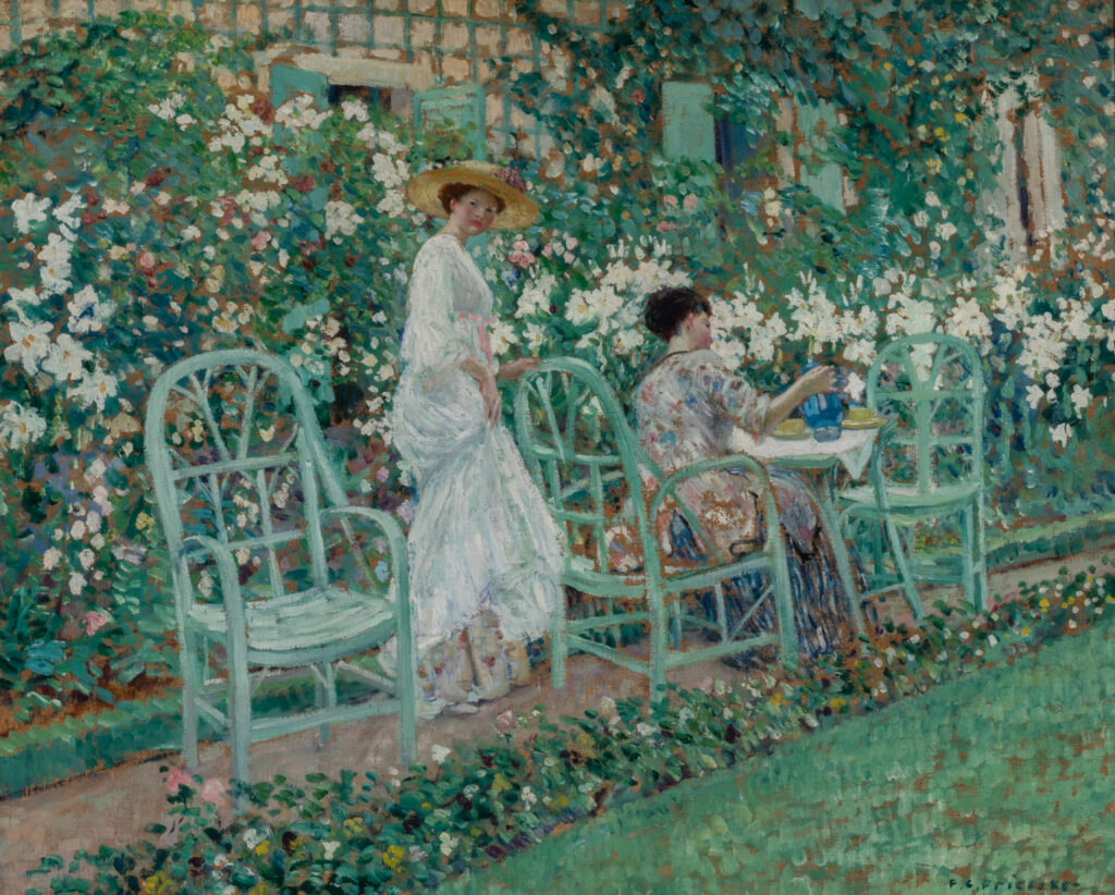 Painting of two women in a garden. One woman stands and looks over her shoulder at the viewer while the other woman sits at a table pouring tea.