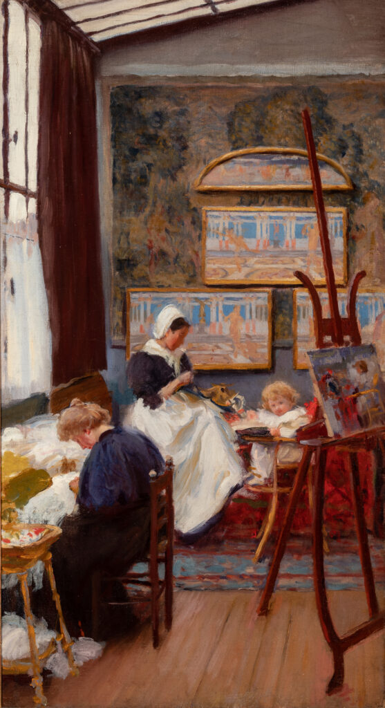Two women sit in a room with a high ceiling and sew.