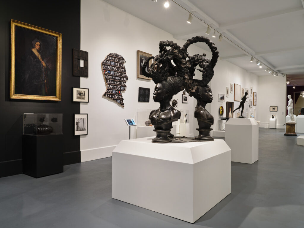 A gallery featuring multiple artworks with black and white wall