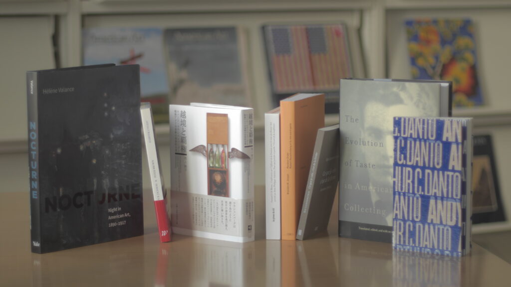 A selection of book stacked on a table. Some show only the book spines, and some show covers.