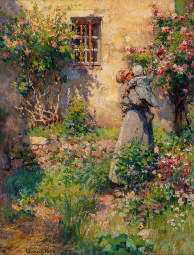 A woman stands in front of a tree in bloom, holding a child. The child reaches out for a flower on the tree.