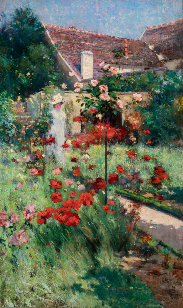 A painting of a garden full of red and pink flowers. There is a small cottage behind the garden and a woman walks on a path between the flowers.