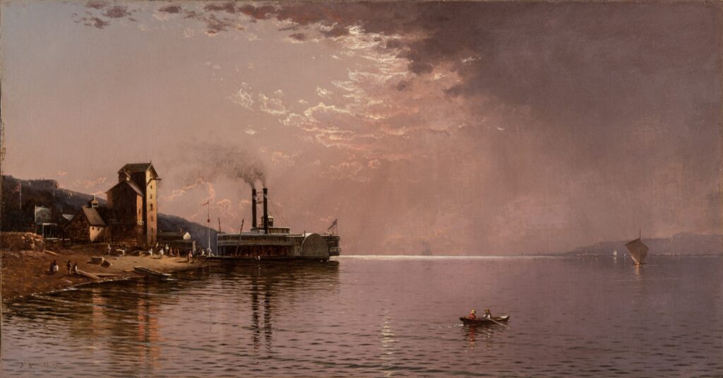 A wide, calm river with a sidewheeler steam boat docked on the shore. The sun is partially obscured by clouds.