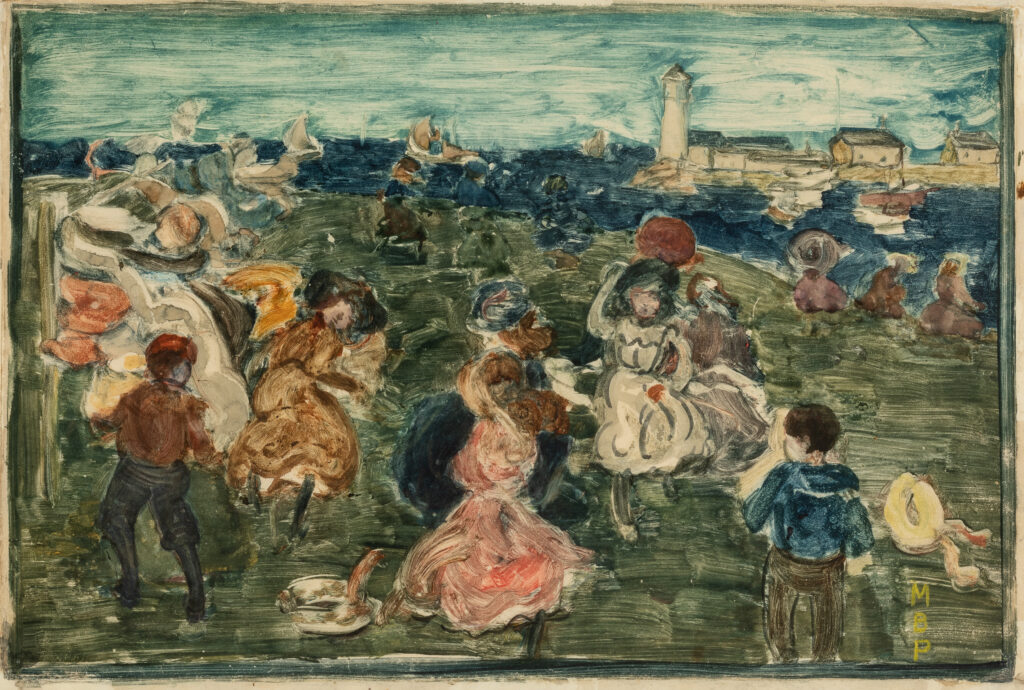 A group of people on a green hill against a blue ocean.