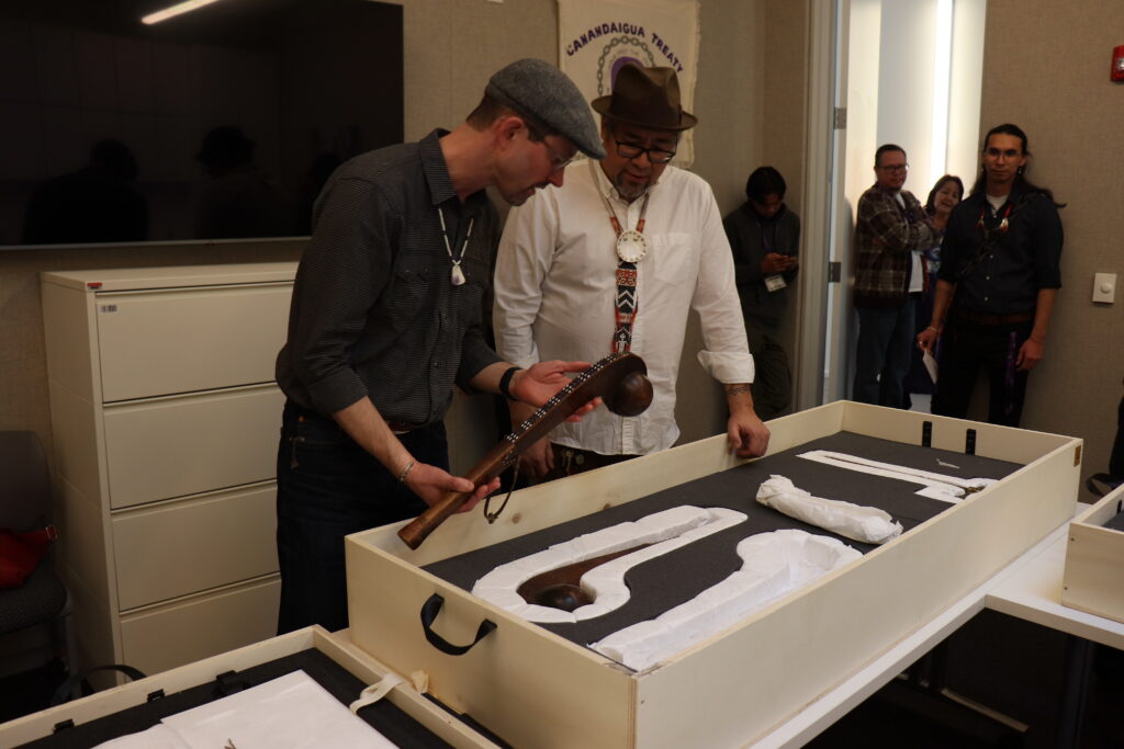 George Ironstrack (Miami Nation Representative) and Michael Galban (SACC Director and Curator, Mono Lake Paiute), look at an object.
