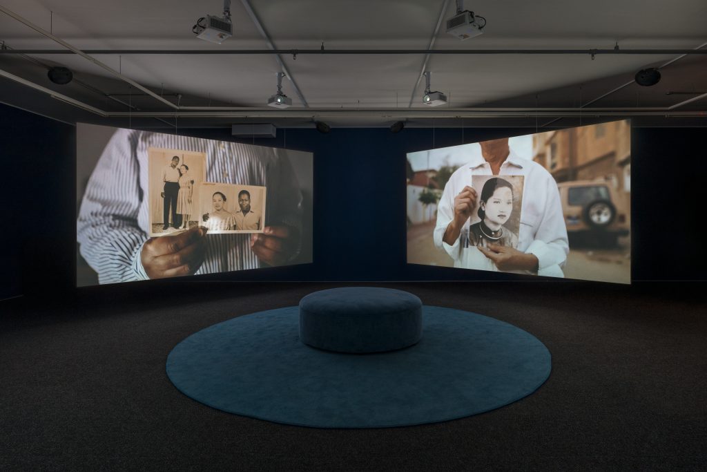 Two screens next to each other facing a round seating area in the center.