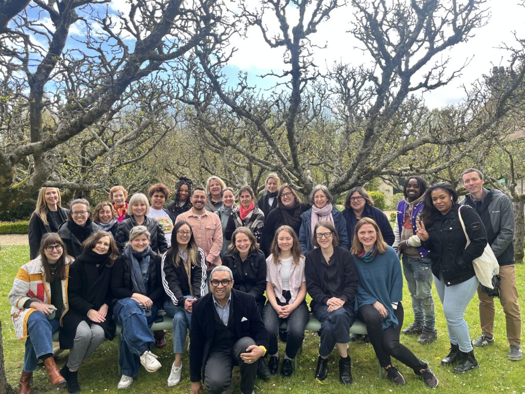 A group of people posing in an orchard.