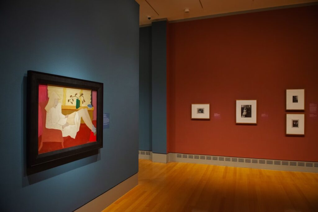 Dark walls with framed works installed on them, including a Terra Foundation Art Collection loan, Milton Avery's "Adolescence."